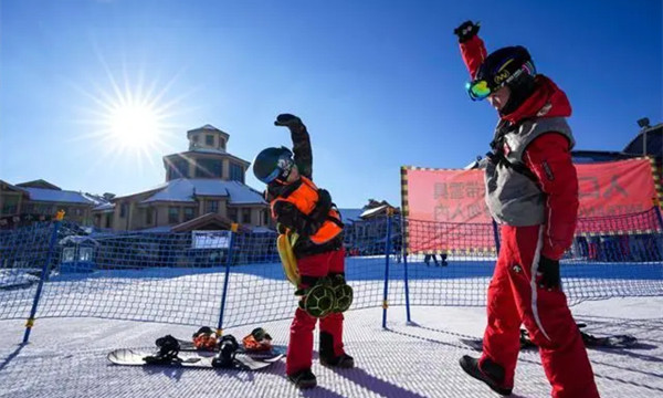 2021年11月15日，在长白山国际度假区滑雪场，一名滑雪爱好者在教练指导下进行热身运动