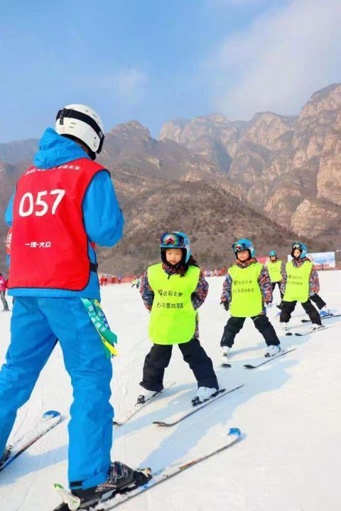 俞佳辉在教小朋友滑雪。